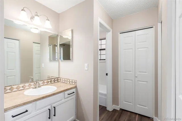 a bathroom with a granite countertop sink and a mirror