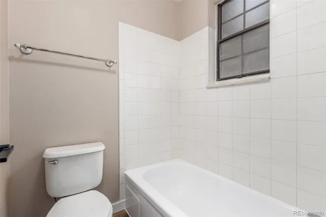 a white toilet sitting next to a bath tub
