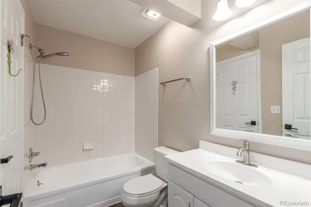 a bathroom with a granite countertop sink a toilet and shower