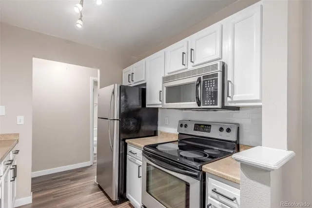 a kitchen with stainless steel appliances a stove a microwave and a refrigerator