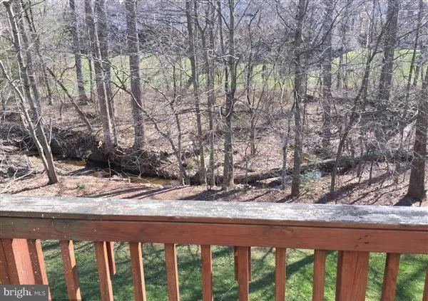 a wooden bench sitting in a backyard of a house