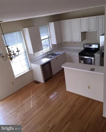 a kitchen with stainless steel appliances wooden cabinets a stove a sink and a microwave