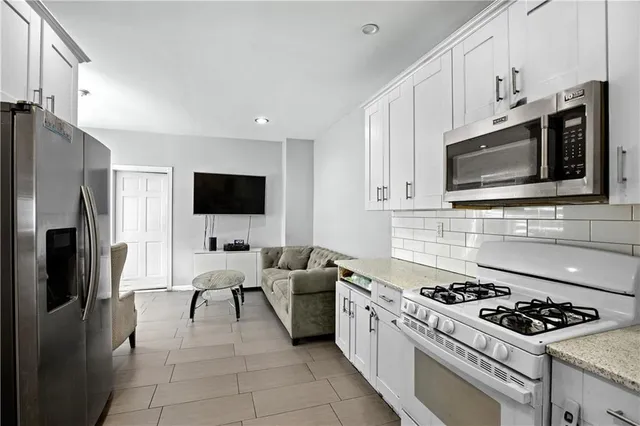 a kitchen with stainless steel appliances a stove microwave and refrigerator