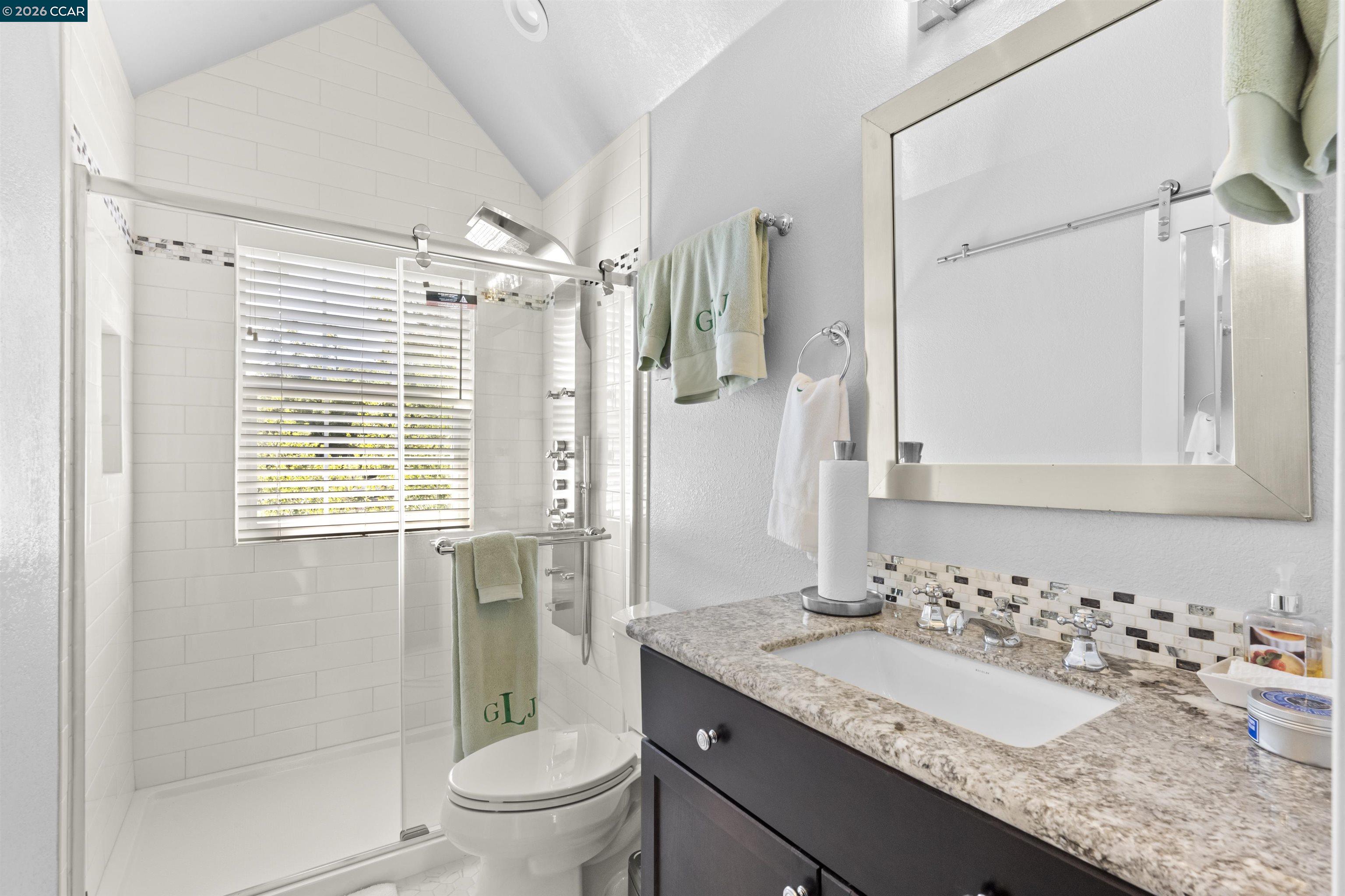 177 Oak Road Alamo, CA 94507 - Photo 40 of 85 a bathroom with a granite countertop sink toilet a mirror and shower