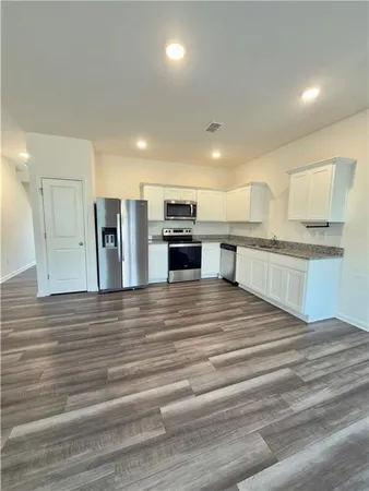 a large kitchen with stainless steel appliances granite countertop a stove and a refrigerator