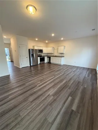 a view of a kitchen with kitchen island a sink wooden floor and a refrigerator