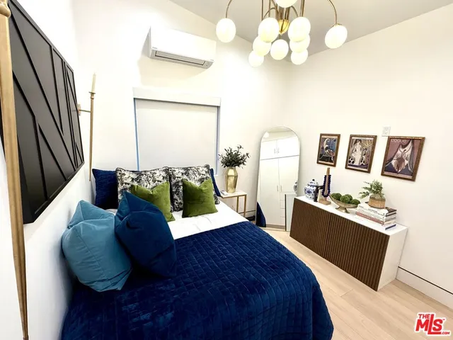 a bed room with a bed mirror and a chandelier