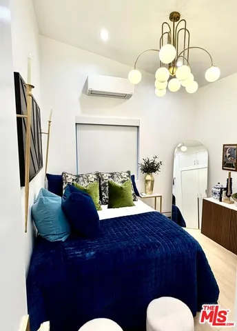 a living room with a bed and chandelier