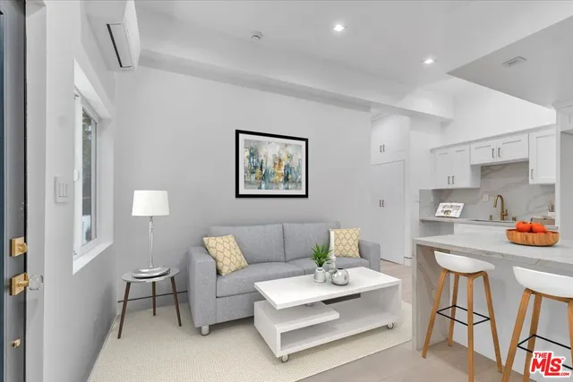 a living room with furniture and a painting on the wall