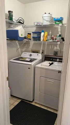 a room with water heater and wooden cabinets