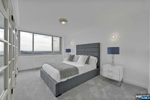 a bedroom with a bed and a large window