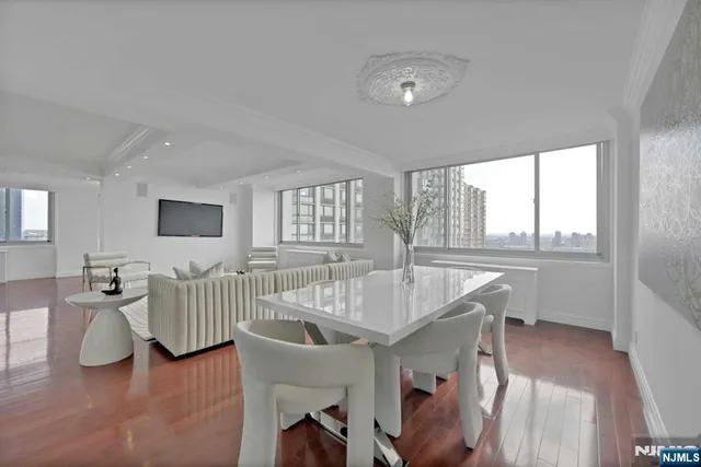 a living room with furniture a wooden floor and a large window
