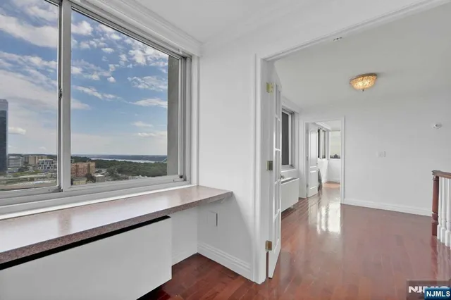 a view of empty room with wooden floor and windows