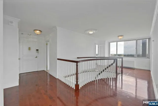 a view of a hallway with wooden floor and windows
