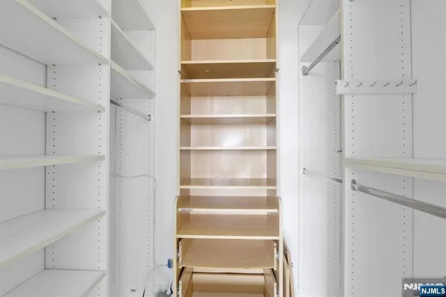 a view of walk in closet with empty racks