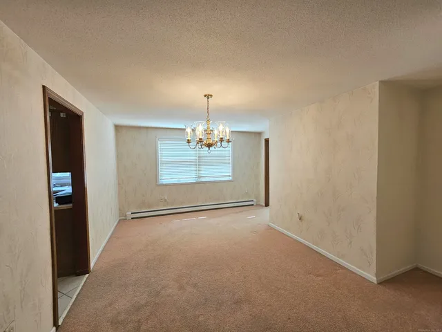 an empty room with chandelier fan and windows