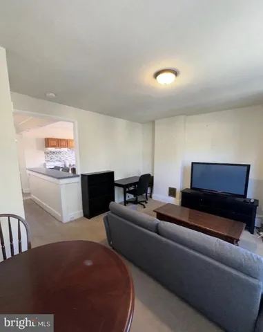 a living room with furniture a flat screen tv and a couch