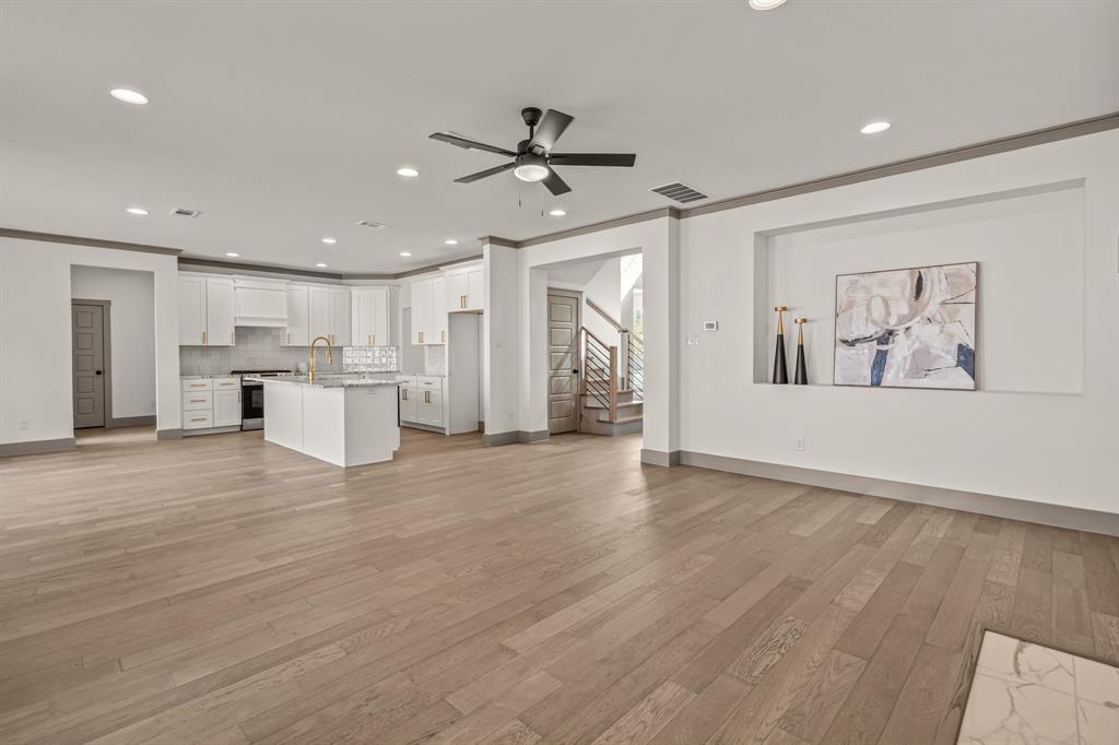 5720 Randolph Court Westworth Village, TX 76114 - Photo 12 of 40 a view of an empty room with wooden floor and a ceiling fan