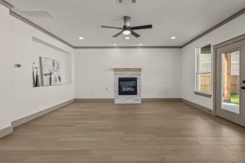 a view of an empty room with a window and fireplace