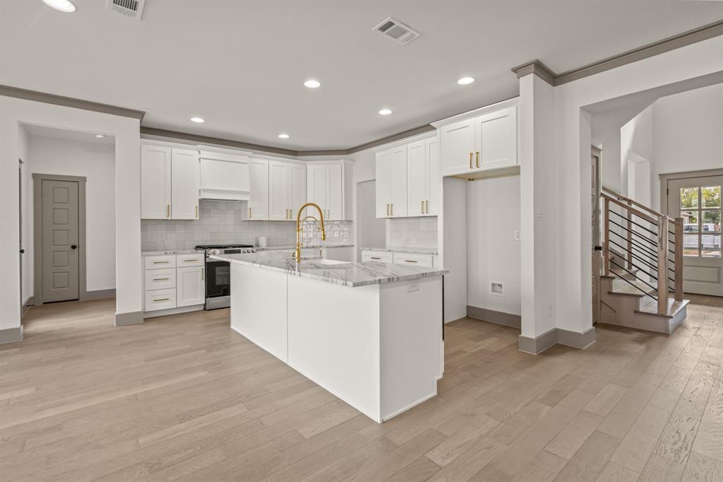 5720 Randolph Court Westworth Village, TX 76114 - Photo 15 of 40 a kitchen with stainless steel appliances granite countertop a refrigerator oven a sink and white cabinets with wooden floor