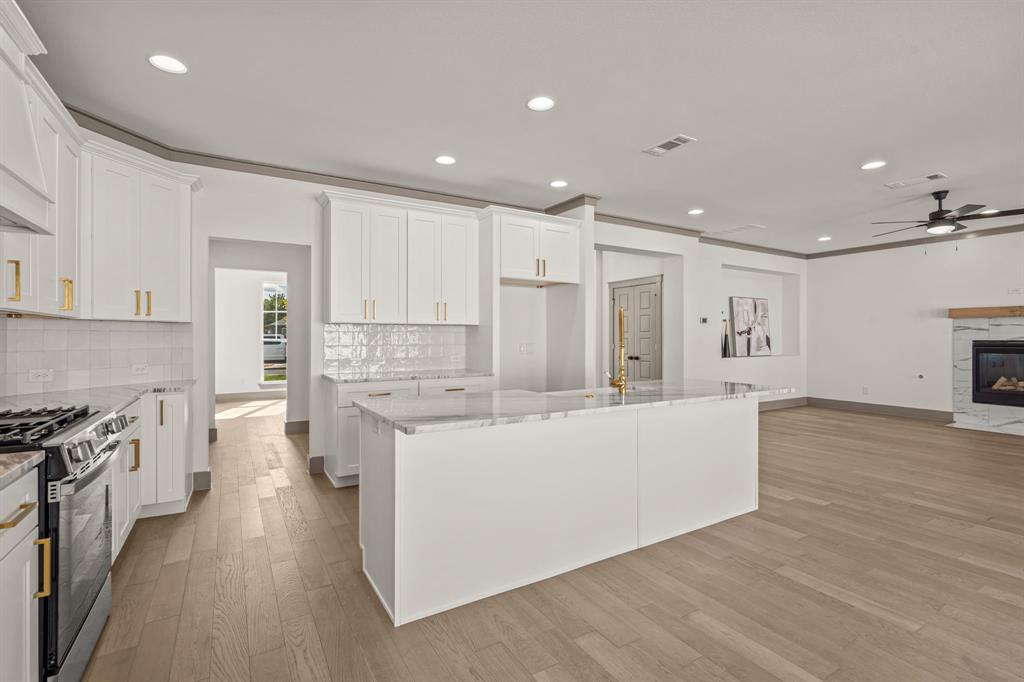5720 Randolph Court Westworth Village, TX 76114 - Photo 18 of 40 a large white kitchen with wooden floor and a sink