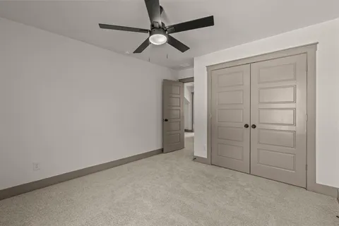 en empty room with closet and a ceiling fan
