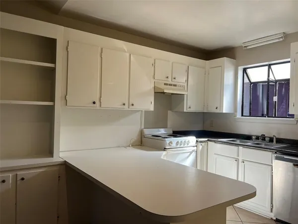 a kitchen with stainless steel appliances granite countertop a stove a white refrigerator a sink a stove and white cabinets