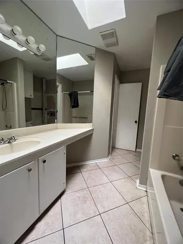 a bathroom with a tub sink and mirror