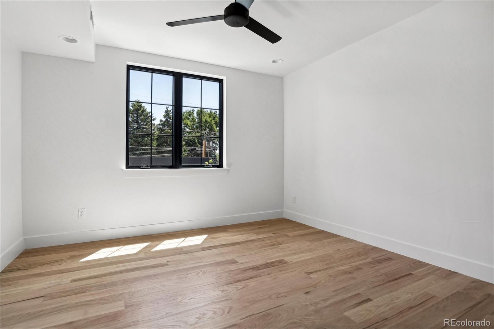 2228 Lowell Boulevard Denver, CO 80211 - Photo 30 of 49 a view of empty room with wooden floor and fan