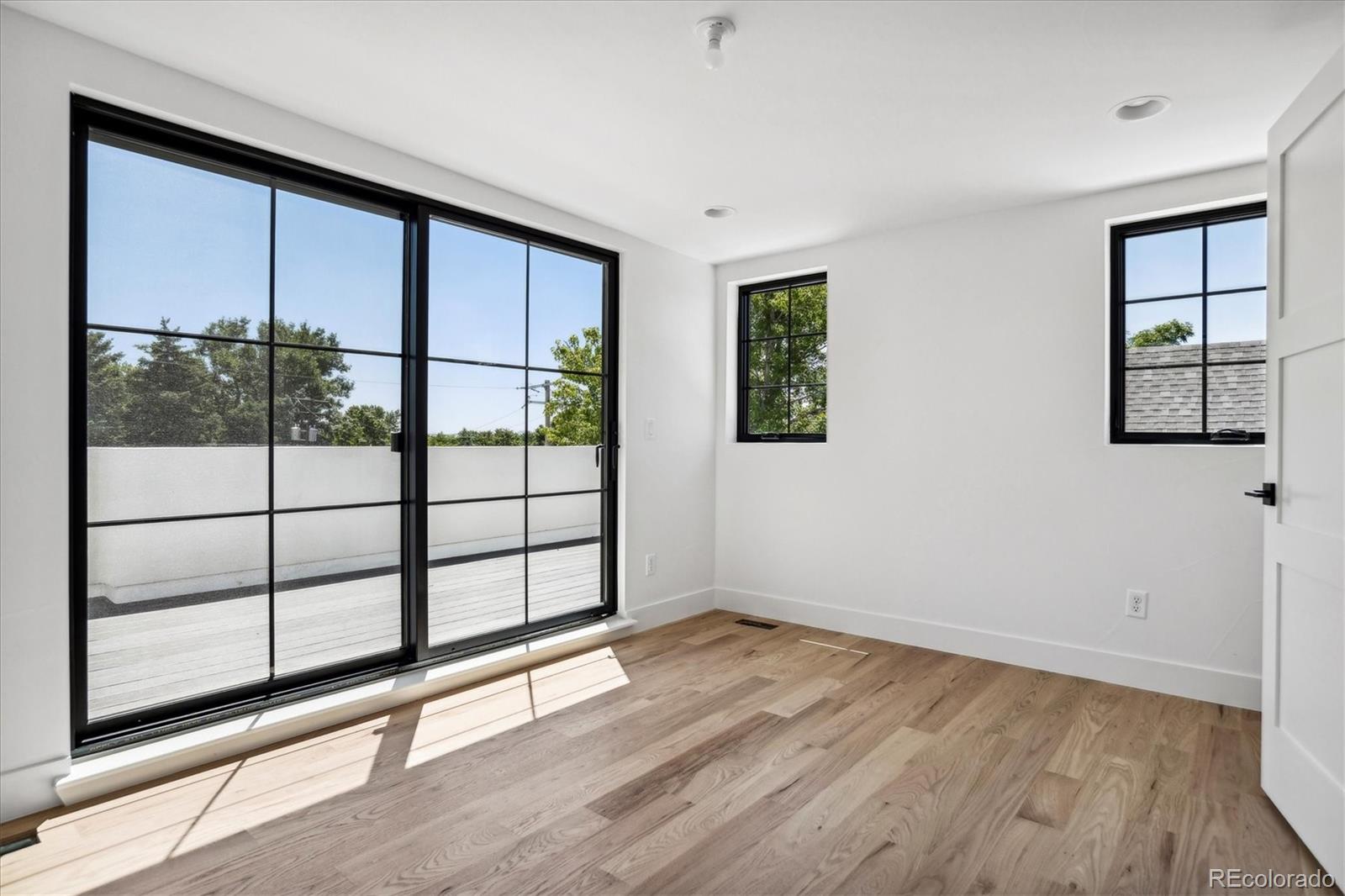 2228 Lowell Boulevard Denver, CO 80211 - Photo 37 of 49 wooden floor with windows and ceiling fan