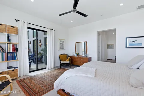 a bedroom with a bed large window and couch
