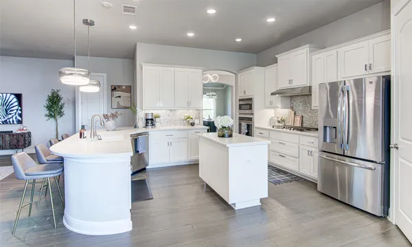 a kitchen with white cabinets and stainless steel appliances