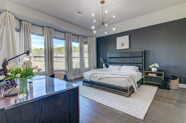 a bedroom with a large bed and a potted plant