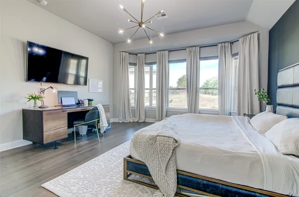 a bedroom with a bed a flat screen tv and a couch