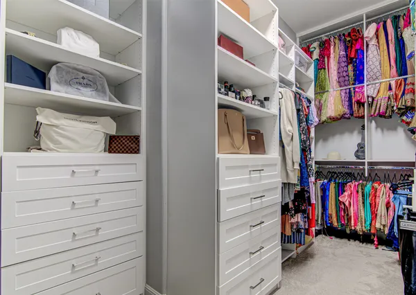 a view of walk in closet with clothes and shoes
