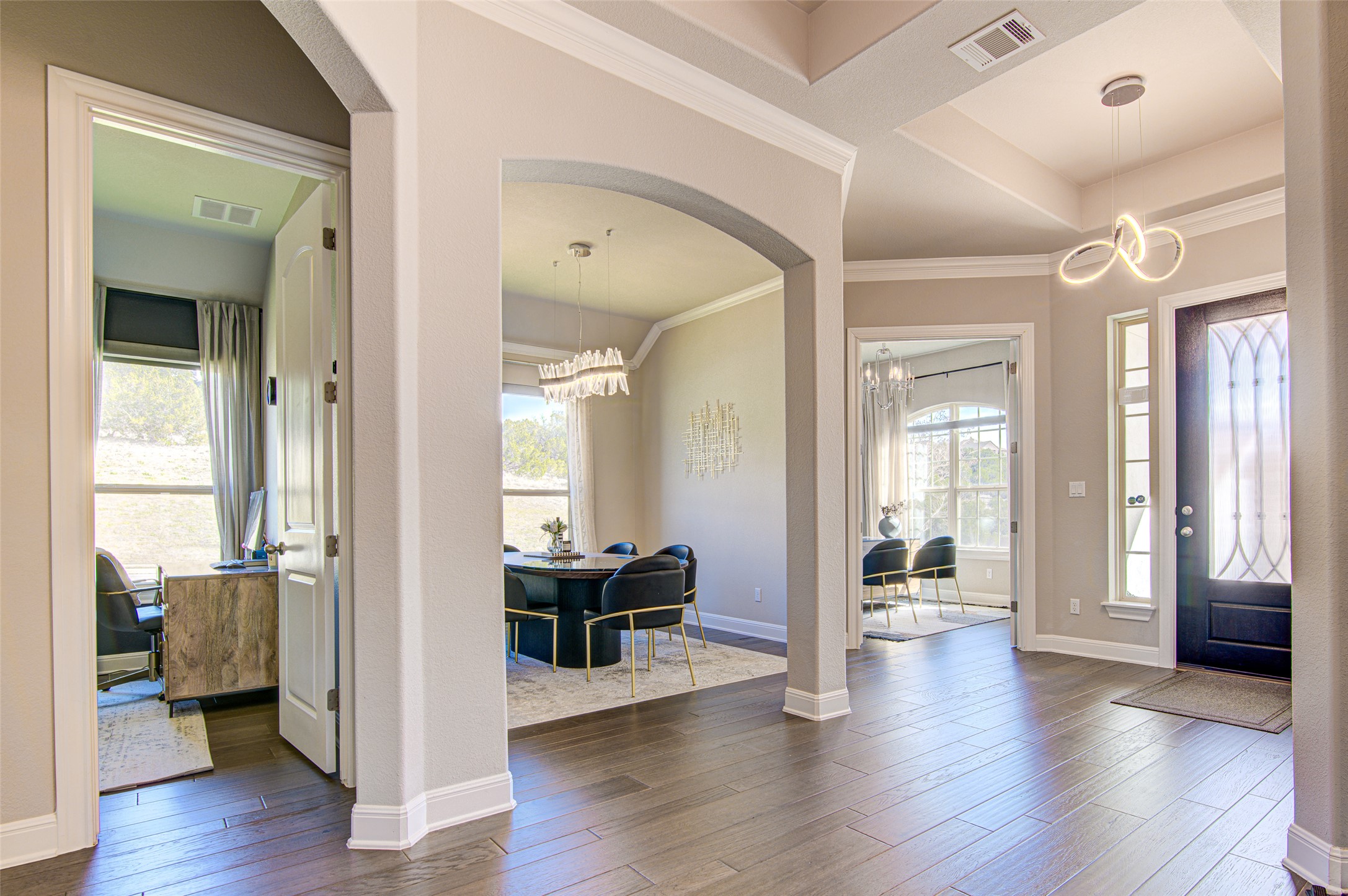 4309 Olive Grv Cove Leander, TX 78641 - Photo 6 of 27 Entrance foyer with arched walkways, a chandelier, dark wood-style floors, and crown molding