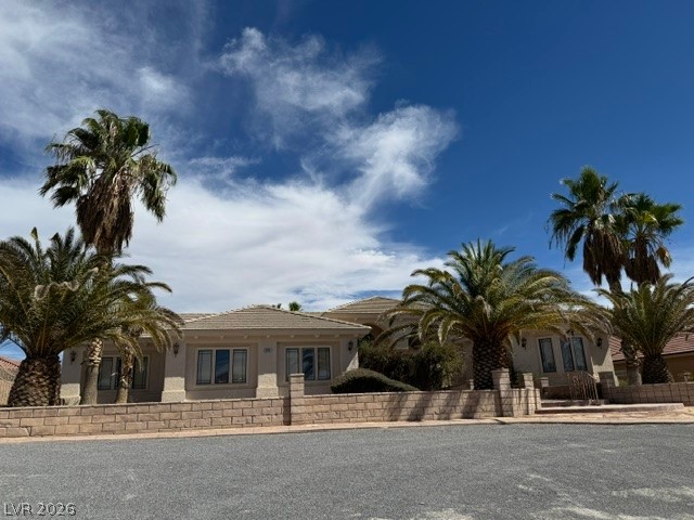 2201 Winery Road Pahrump, NV 89048 - Photo 1 of 3 Stately palm trees frame a classic stone facade under expansive blue skies.