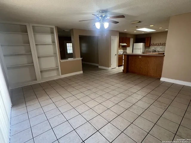 a view of a kitchen with furniture and a refrigerator