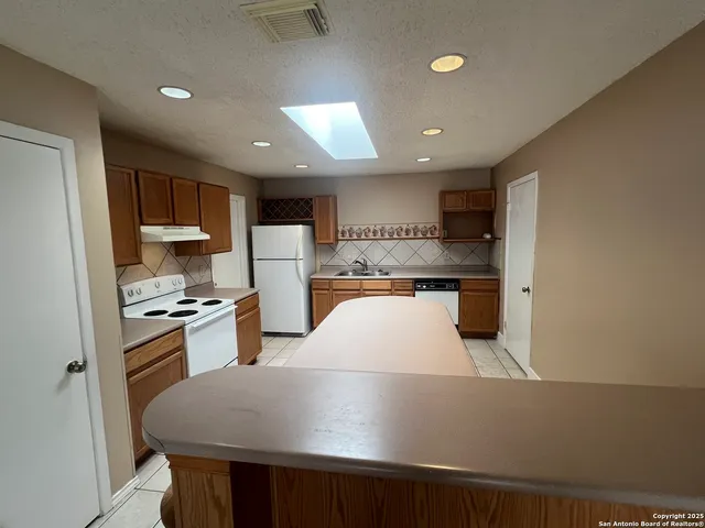 a kitchen with stainless steel appliances a refrigerator sink and stove