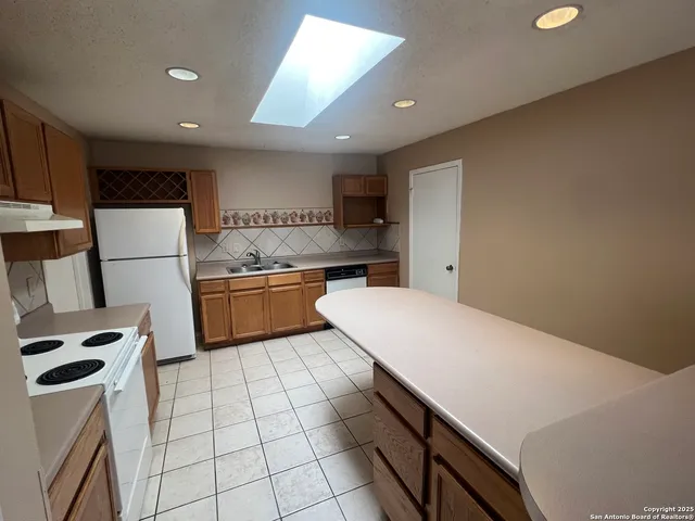 a kitchen with a refrigerator a stove top oven and cabinets