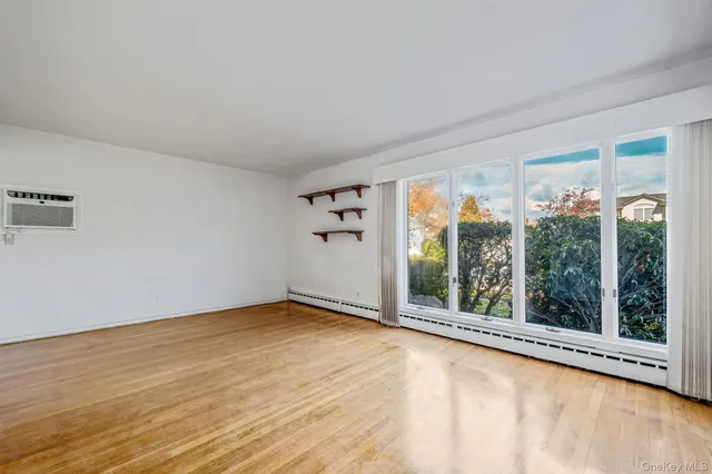a view of a big room with wooden floor and windows
