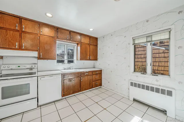 a kitchen with granite countertop white cabinets and white appliances