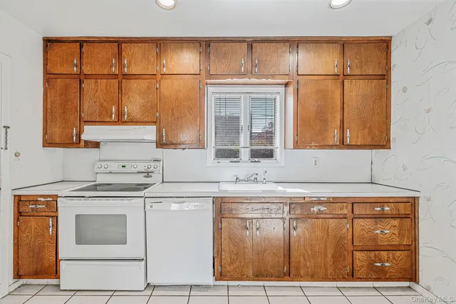 a kitchen with granite countertop a sink and a refrigerator
