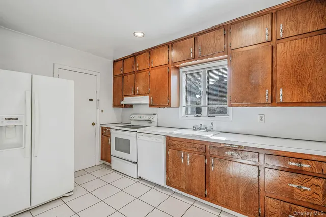a kitchen with stainless steel appliances granite countertop a sink and a refrigerator