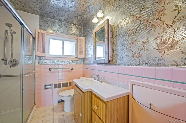 a bathroom with a sink a toilet and shower