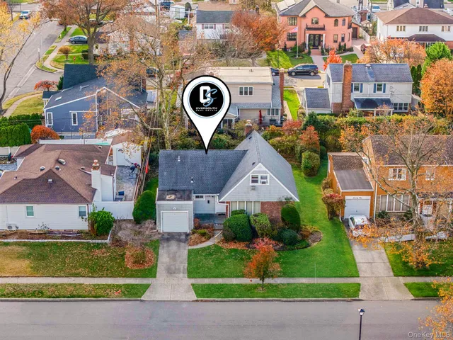 an aerial view of residential houses with outdoor space and parking