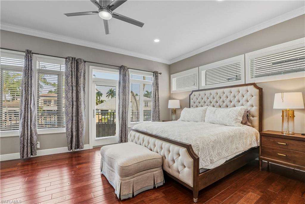 453 18th Avenue South Naples, FL 34102 - Photo 24 of 47 a bedroom with a large bed and a chandelier