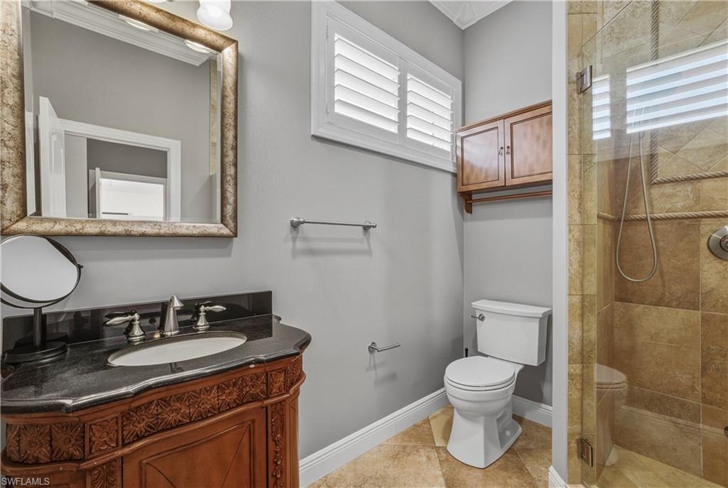 453 18th Avenue South Naples, FL 34102 - Photo 32 of 47 a bathroom with a granite countertop sink toilet and mirror