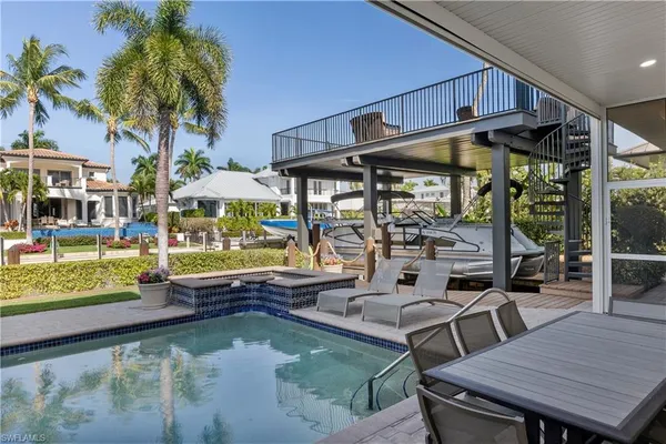 a view of a patio with table and chairs potted plants and palm tree