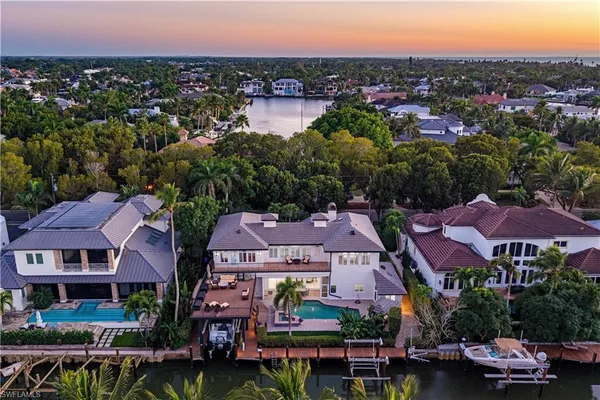 an aerial view of residential houses with outdoor space and trees